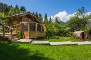 a large wooden cabin in a field of green grass at Squaw Peak in Morzine +13 photos