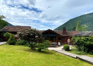 a log cabin with a grass yard in front of it at Squaw Peak in Morzine