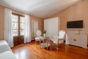 a living room with a table and chairs and a tv at Hotel Sangallo in Monte San Savino