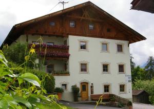 a white house with a wooden roof at Thalerhof-Markus in Roppen