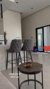 two chairs and a table in a living room at شاليه اغصان الباحة in Al Baha