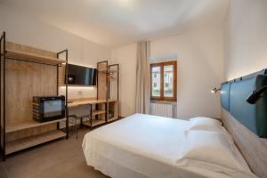 a bedroom with a bed and a desk with a television at Hotel Sangallo in Monte San Savino