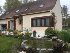 a house with a pond in front of it at Au Pré Fleury in Fleury-en-Bière