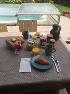 a table with breakfast foods on a table with a table cloth at Au Pré Fleury in Fleury-en-Bière