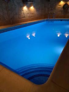 a large swimming pool with blue lights on it at Il- Pellikan Farmhouse in Għajnsielem