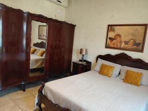 a bedroom with a bed and a large mirror at Il- Pellikan Farmhouse in Għajnsielem