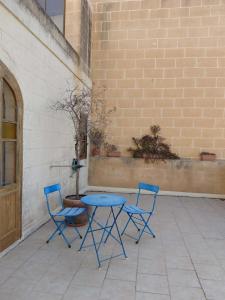 two blue chairs and a table on a patio at Il- Pellikan Farmhouse in Għajnsielem