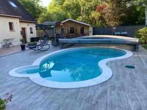 a swimming pool in a yard with a patio at Au Pré Fleury in Fleury-en-Bière