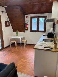 a kitchen with a sink and a table in a room at Bungalow Refúgio do Pezo T0 in Melgaço