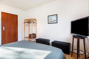 a bedroom with a bed and a flat screen tv at Schicke kleine Bude in Neuenkirchen
