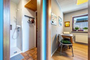 a bathroom with a shower and a desk and a sink at Schicke kleine Bude in Neuenkirchen +13 photos