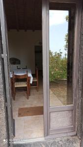 an open door to a patio with a table at Casa rustica in SantʼAlfio +18 photos