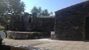 an old stone building with a stone wall at Casa rustica in SantʼAlfio