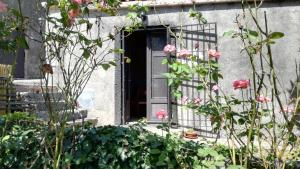 a front door of a house with pink flowers at Casa rustica in SantʼAlfio