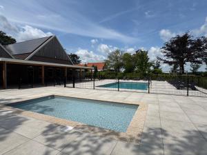 a swimming pool in front of a house at Residence Winterswijk in Winterswijk