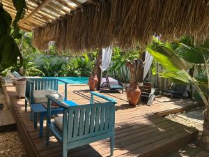 a patio with chairs and a table and a straw umbrella at Pousada La vida boutique in Icaraí