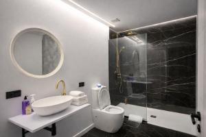 a bathroom with a sink and a toilet and a mirror at LEMIGA SUiTE VALENCIA in Valencia