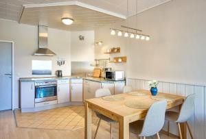 a kitchen with a wooden table and chairs in a kitchen at Haus Schildt, FeWo 4 in Duhnen