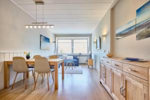 a kitchen and dining room with a table and chairs at Haus Schildt, FeWo 4 in Duhnen