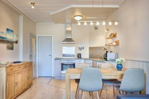 a kitchen and dining room with a table and chairs at Haus Schildt, FeWo 4 in Duhnen