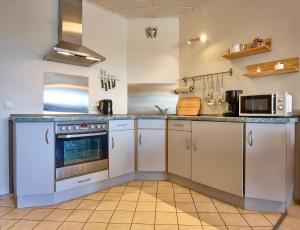 a kitchen with white cabinets and a microwave at Haus Schildt, FeWo 4 in Duhnen +24 photos