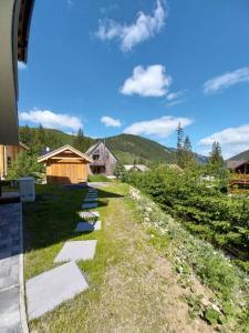 a path leading up to a house with mountains in the background at Chalet OSHI Jasna in Belá