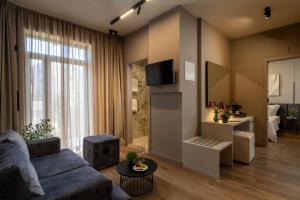 a living room with a blue couch and a tv at Hotel Aquarius Dubrovnik in Dubrovnik