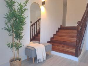 a hallway with stairs with a chair and a plant at Rosales Collection Vacation Villa in Medina de Pomar +26 photos