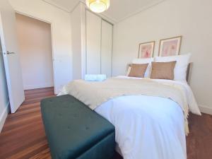 a bedroom with a large bed with a blue ottoman at Rosales Collection Vacation Villa in Medina de Pomar