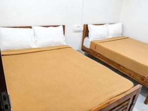 two beds sitting next to each other in a room at LS Residency Ac in Thiruchendur