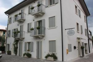 a white building with potted plants on the balconies at Punto 41 in Peschiera del Garda