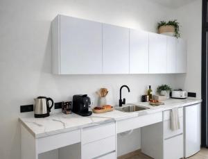 a white kitchen with white cabinets and a sink at LEMIGA SUiTE VALENCIA in Valencia