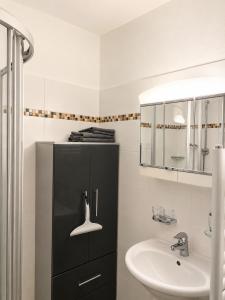 a bathroom with a sink and a black cabinet at Ferienwohnung Evi in Sankt Gilgen +15 photos