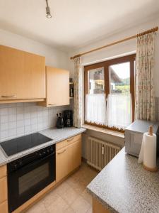 a kitchen with a stove and a window in it at Ferienwohnung Evi in Sankt Gilgen