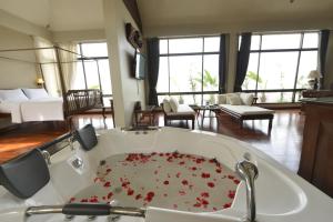 a bathroom with a tub filled with red flowers at Sourire at Rattanakosin Island Hotel in Bangkok +191 photos