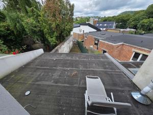 a white chair sitting on top of a roof at Home cinema in Liège