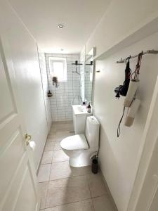 a white bathroom with a toilet and a sink at Hygge Home Aalborg, Free Parking & 15 Min to City Centre in Nørresundby