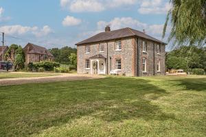 an old brick house on a field of grass at Timberley House by Group Retreats in Pulborough