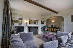 a living room with a couch and a fireplace at Timberley House by Group Retreats in Pulborough