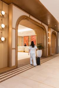 a woman walking through an archway in a lobby at Amora Hotel Adelaide in Adelaide