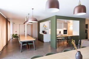 a dining room and kitchen with tables and chairs at Het Kasterhuis - Gastenverblijf in Wetteren