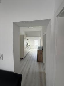 an empty living room with white walls and wood floors at Deluxe Apartment II in Velpke +1 photo