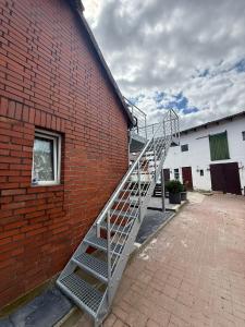a metal staircase leaning against a brick building at Deluxe Apartment II in Velpke