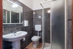 a bathroom with a toilet and a sink and a shower at Hotel La Carica in Pastrengo