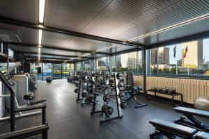 a gym with a lot of equipment in a building at Amora Hotel Adelaide in Adelaide