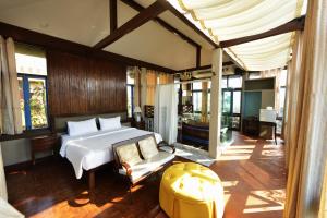a bedroom with a bed and a chair in a room at Sourire at Rattanakosin Island Hotel in Bangkok