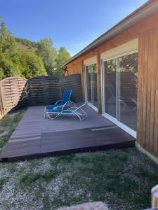 a deck with a chair on it next to a house at Chalet Bien-être, Piscine, Spa in La Chapelle-dʼAlagnon