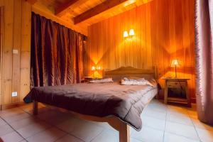 a bedroom with a bed in a wooden room at Chalet Bien-être, Piscine, Spa in La Chapelle-dʼAlagnon