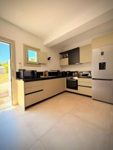 a large kitchen with white appliances and a large window at Apademia Comfort Studio 65sqm in Skiros +11 photos
