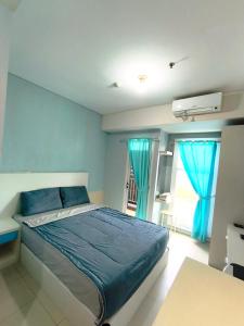 a bedroom with a bed with blue sheets and a window at Studio Apartemen Parahyangan Residence by Anton in Bandung +13 photos